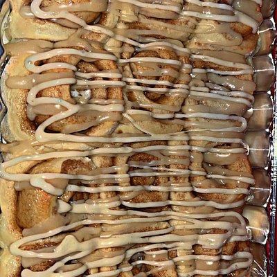 Pan of cinnamon rolls with icing drizzle