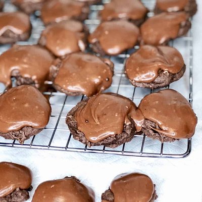 Texas sheet cake cookies cooling on a rack under chocolate glaze